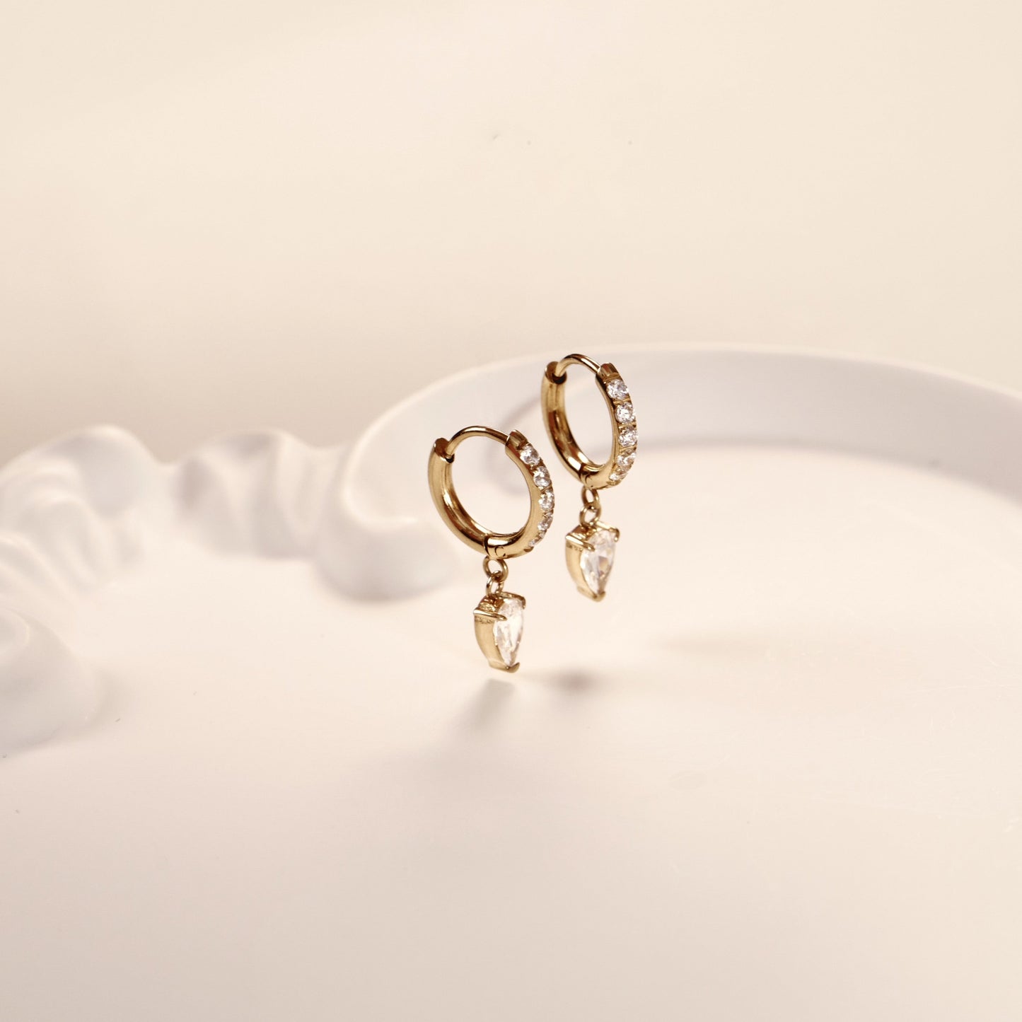 Paire de boucles d'oreilles or en acier inoxydable avec pierres de zircone. Elégante, résistante et raffinée.