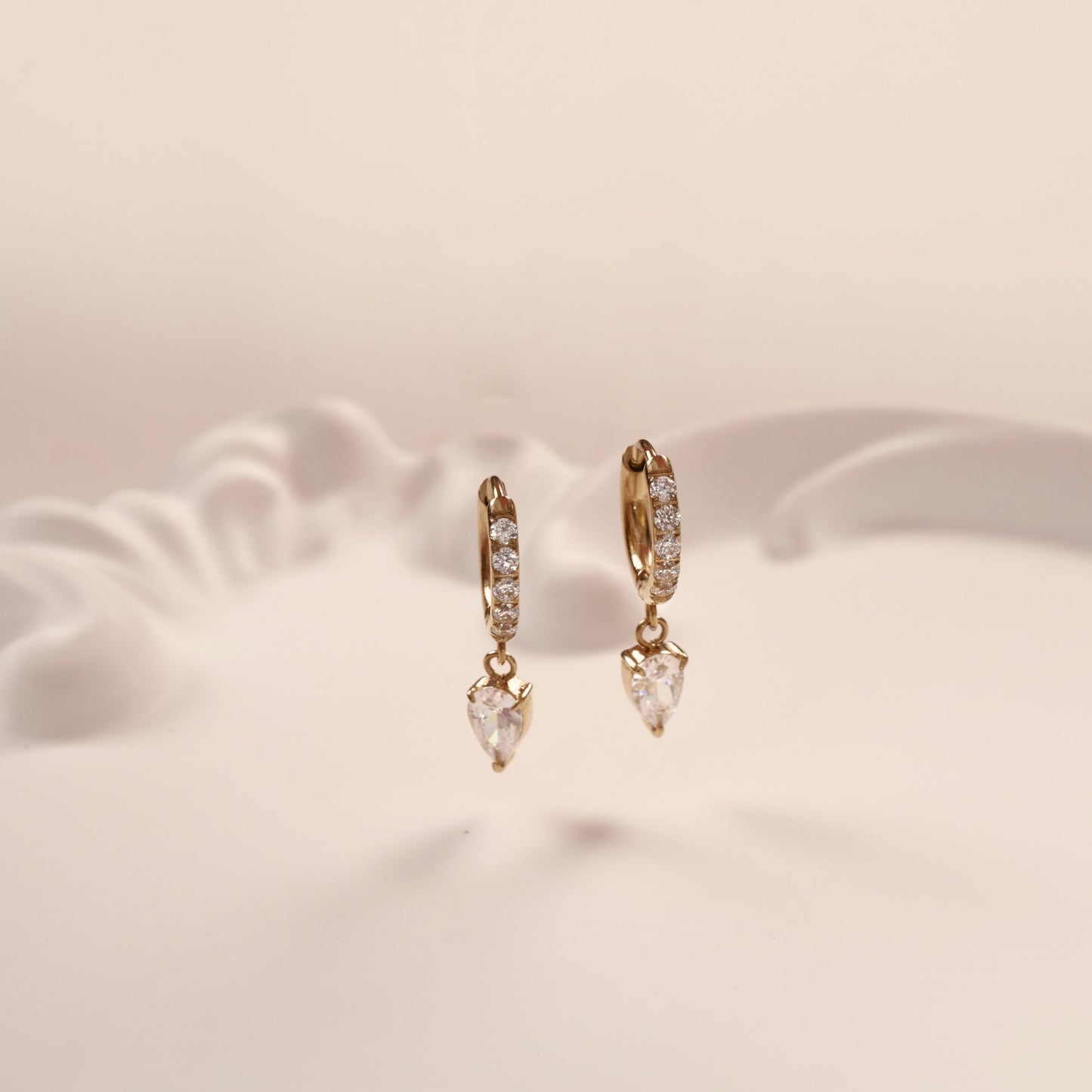 Paire de boucles d'oreilles or en acier inoxydable avec pierres de zircone. Elégante, résistante et raffinée.