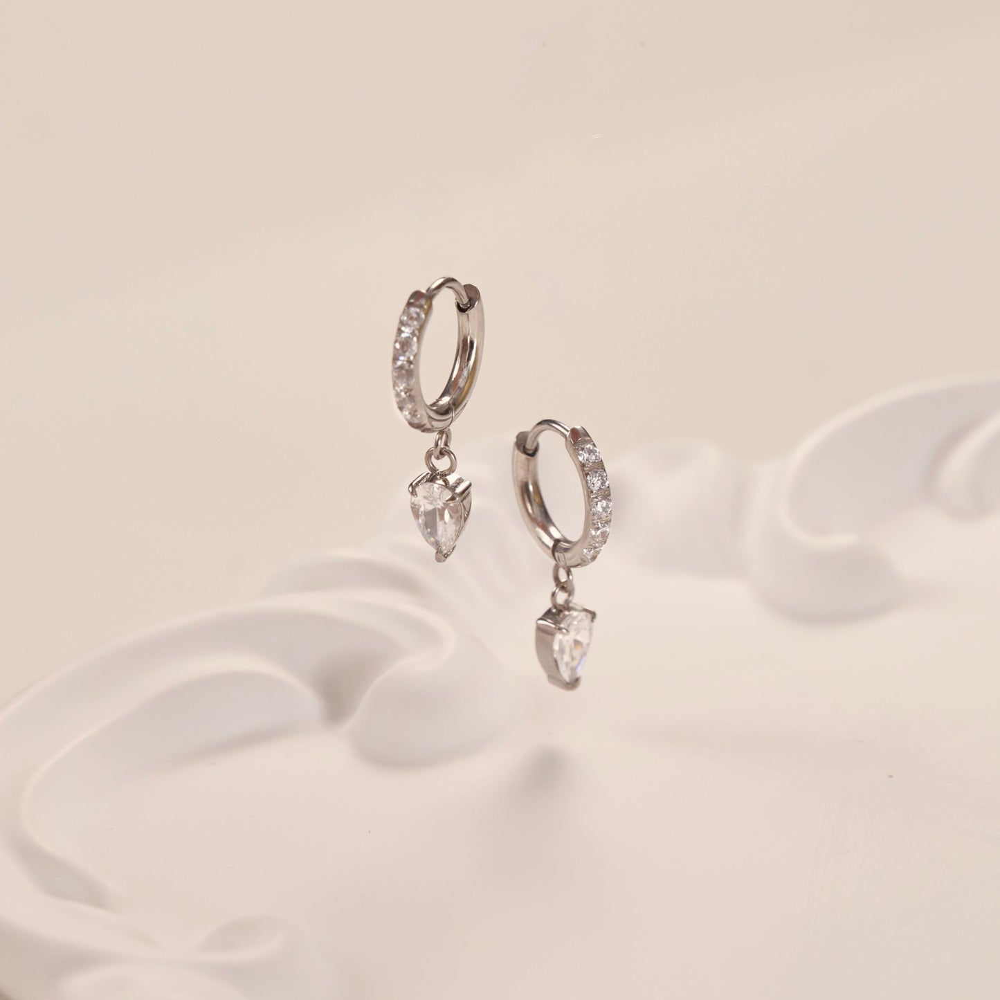 Paire de boucles d'oreilles argent en acier inoxydable avec pierres de zircone. Elégante, résistante et raffinée.