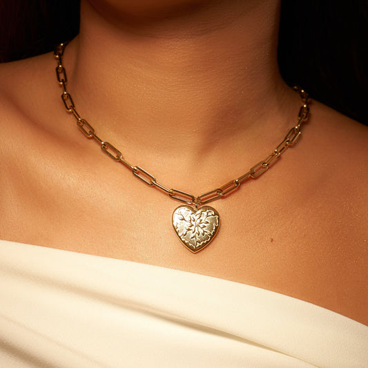 Collier doré en acier inoxydable, avec pendentif en forme de cœur, avec un design unique rappelant des feuilles d'olivier. Chaîne à grosse maille réglable. Bijou résistant, élégant et symbolique.